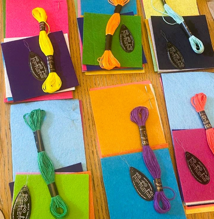 A range of piece of felt with embroidery thread on top.