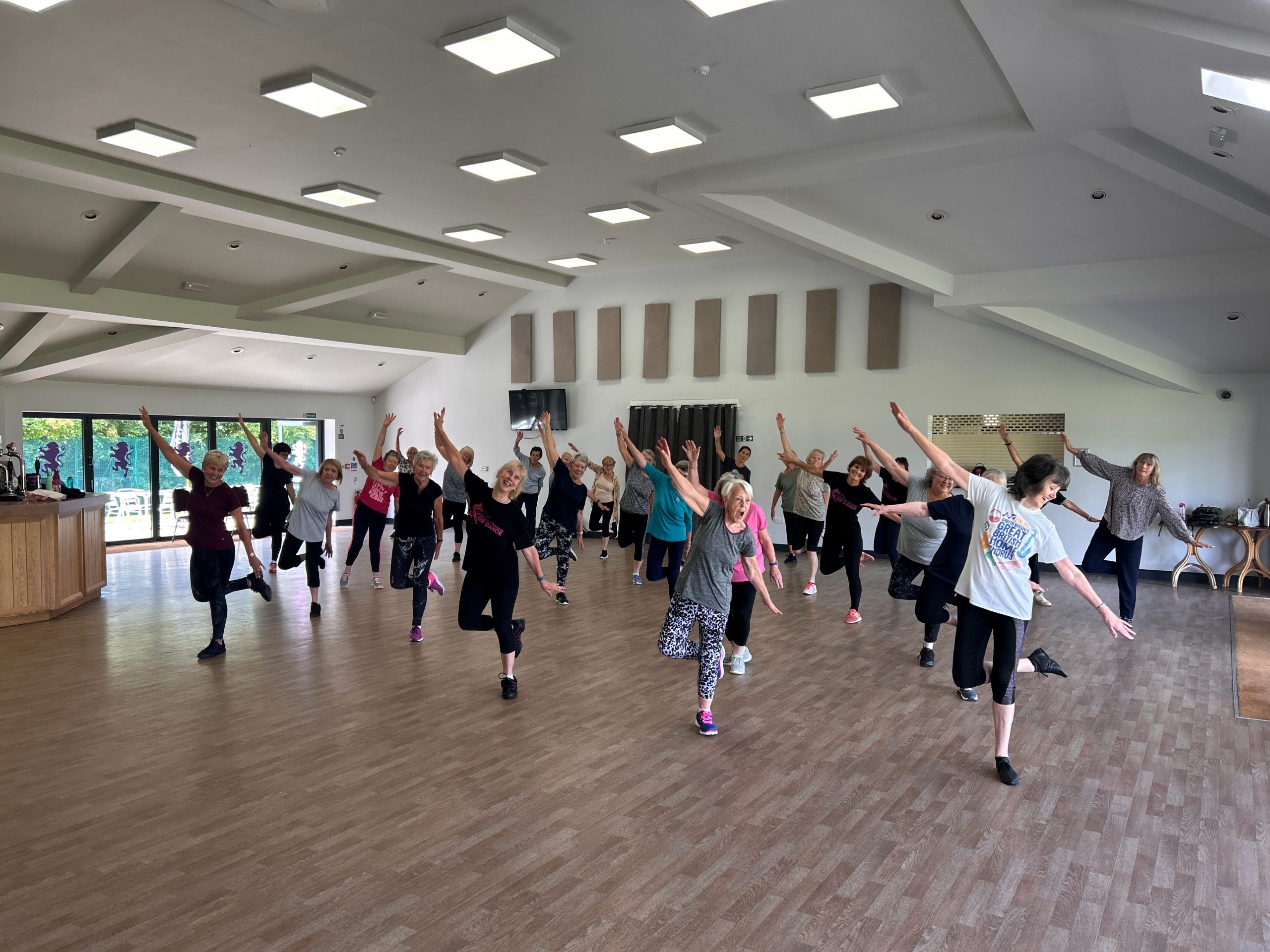 A room full of women holding their hands up and dancing.