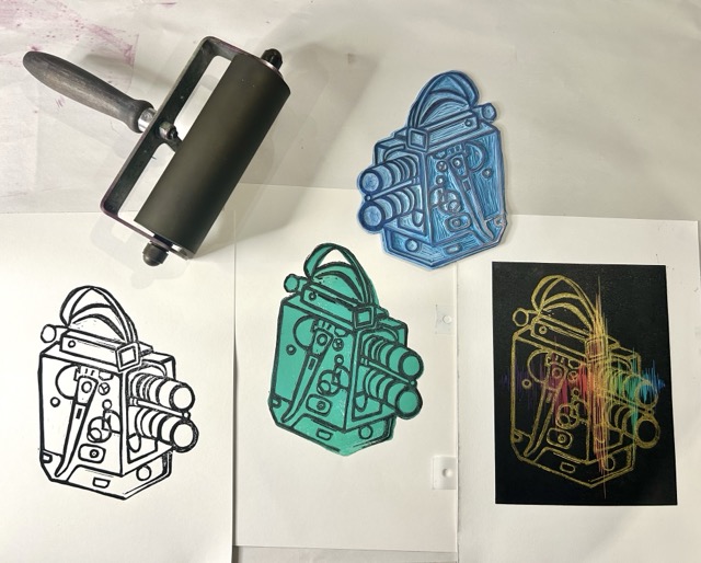 A roller with a lino block cut into a vintage camera. Below are multiple prints using the same block.