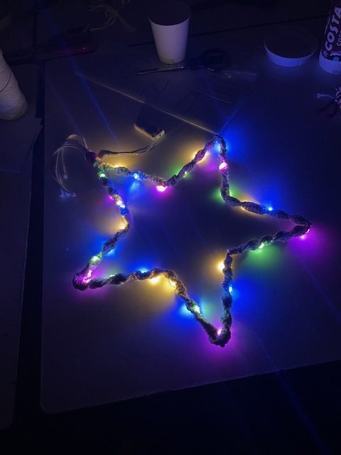 A star made of macramé covered in colourful, bright lights.